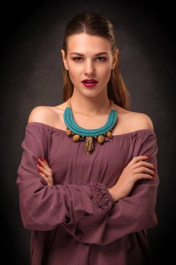 Güzel genç kadın esmer modeli el yapımı aksesuarlar moda takı kolye. Kameraya bakıyor. Moda fotoğraf.