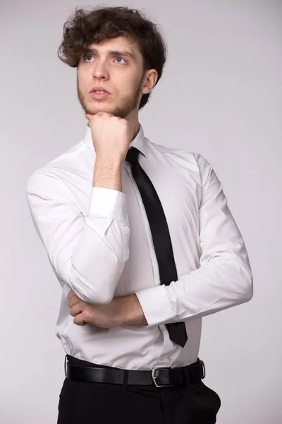 Портрет красивого задумчивого мужчины в белой рубашке, смотрящего вверх, думающего о проблеме, держащего подбородок . — стоковое фото