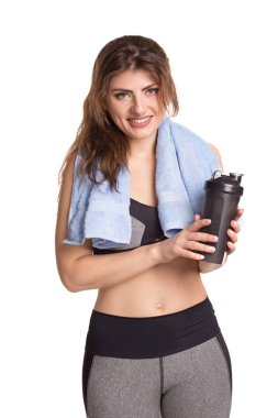 Bir shaker ve havlu ile atletik genç gülümseyen kadın.