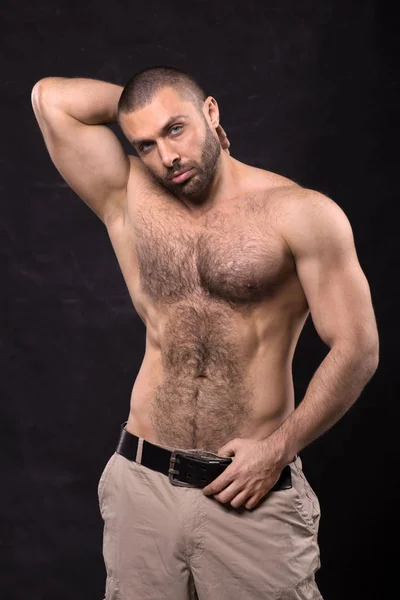 Acımasız kas üstsüz adam, kot pantolon. Ayakta rahatlatıcı vücut geliştirmeci.