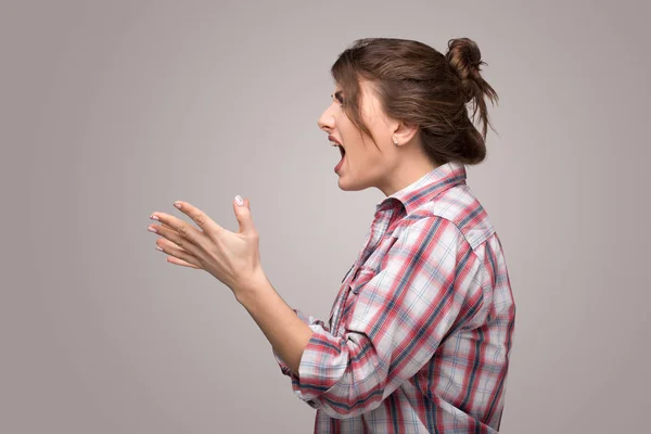 Profiel van:: een boos woede jonge vrouw schreeuwen geïsoleerd op een grijs — Stockfoto