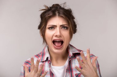 Duygusal öfkeli genç kadın gri arka planda çığlık. Nefret ve öfke duyguları, yüz ifade kavramı.