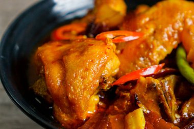 Baharatlı ve ekşi soslu kızarmış tavuk, Tayland biberi, kırmızı biber ve patates..