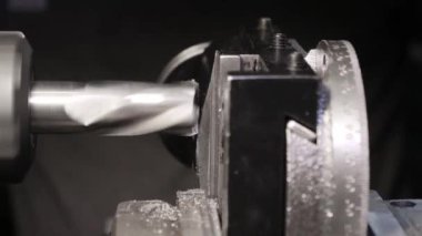 Metal işçiliği yapan metal torna torna makinesi, dönen ve başlık arasında sabitlenen iş parçasını açarken değirmen aracını kapat, 4k.