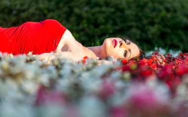 Güzel genç kız kırmızı yaz parkta yürüyor