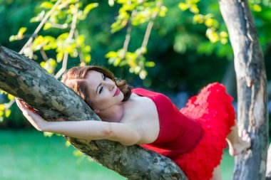 Güzel genç kız kırmızı yaz parkta yürüyor