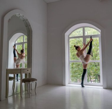 Güzel genç kız pencere ve ayna tarafından stüdyoda dans