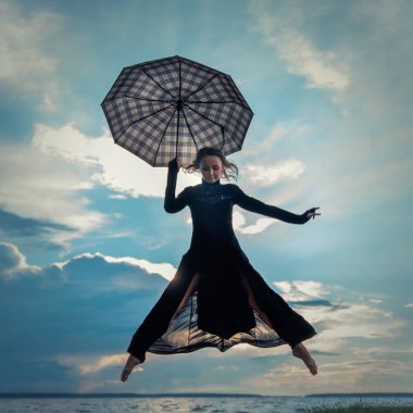 Göl kenarında dans şemsiye ile siyah elbiseli güzel genç kız