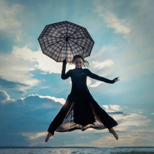 Göl kenarında dans şemsiye ile siyah elbiseli güzel genç kız