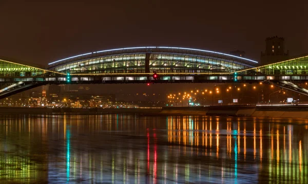 夜の川の背景にイルミネーションの多数に照らされた美しい橋 — ストック写真