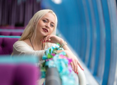 Mavi ve bordo tonlarında bir kafede güzel genç kız