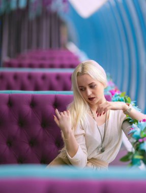 Mavi ve bordo tonlarında bir kafede güzel genç kız