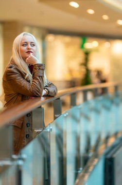 Zarif korkulan arka planda alışveriş merkezinde güzel genç kız