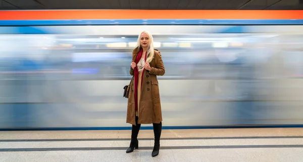 Beautiful young girl in the subway on a blurred background in train traffic