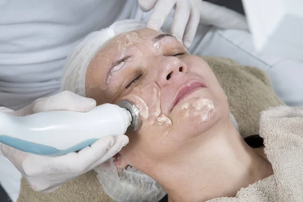 Laser And Ultrasound Facial Treatment-Middle-Aged Woman Getting Anti Aging Facial Massage While Lying With Eyes Closed And Resting At The Beauty Salon Closeup