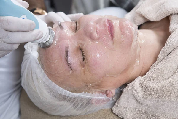 Laser And Ultrasound Facial Treatment-Middle-Aged Woman Getting Anti Aging Facial Massage While Lying With Eyes Closed And Resting At The Beauty Salon Closeup