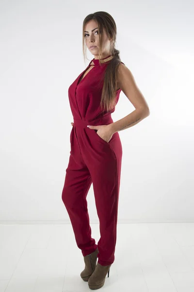 Young Fashion Girl Posing In Elegant Red Overalls And Brown High Heels, Full Body Studio Shot Over White Background