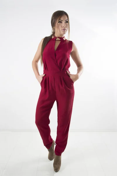 Young Fashion Girl Posing In Elegant Red Overalls And Brown High Heels, Full Body Studio Shot Over White Background