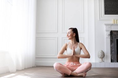 Kadın evde lotus pozisyonu. Pratik yoga genç mutlu kız portresi.