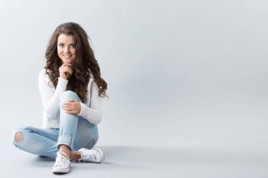 Güzel kadın ve kopya alanı boş duvar. Katta oturan genç gülümseyen casual kız.