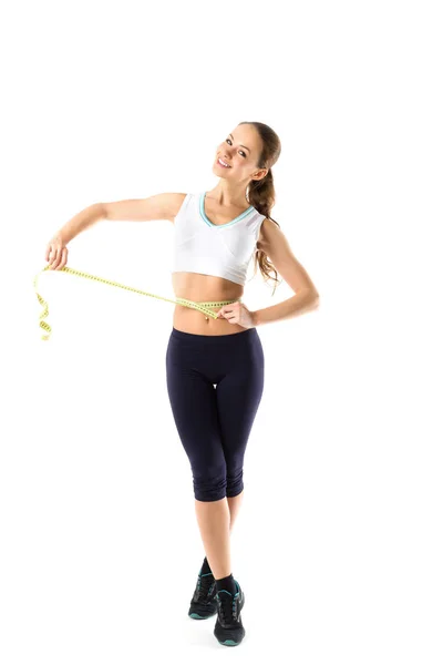 年轻的微笑的女人在运动服测量她的腰部测量磁带 孤立在白色背景 — 图库照片
