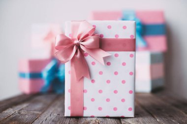 Şık el yapımı Hediyelik kutu lekeli ahşap arka plan üzerinde pembe fiyonklu.