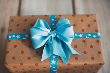 El yapımı hediye kutusu ahşap eski masa üzerinde mavi kurdele ile.