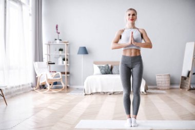 Genç kadın ağaç poz evde, Yoga yapıyor.