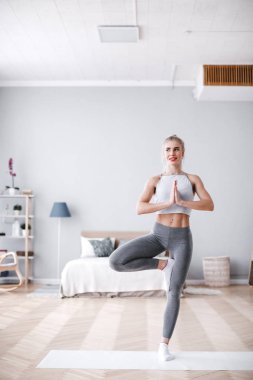 Kapalı çalışma dışarı, yoga egzersiz yaparak, Vrksasana duruş, ağaç poz, tam uzunlukta duran güzel kadın.