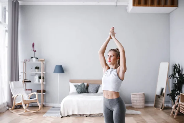 Mujer atractiva joven practicando yoga, ejercitándose, usando ropa deportiva . — Foto de Stock