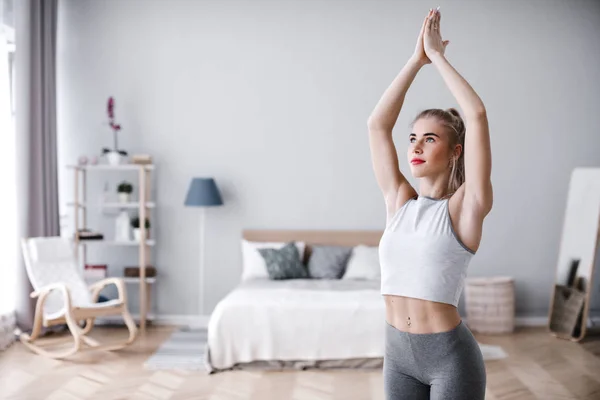 Retrato de atractiva joven hembra con hermoso cuerpo atlético practicando yoga en casa . — Foto de Stock