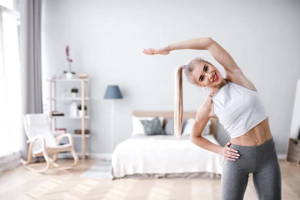 Hermosa mujer deportiva haciendo ejercicio en casa. — Foto de Stock