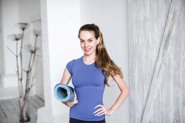 Gesunde Fitness-Frau mit blauer Yogamatte zu Hause vor dem Training. — Stockfoto