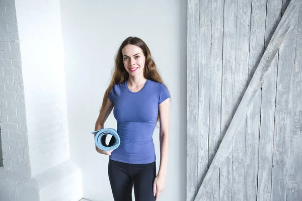 Женщина с синим ковриком для йоги дома после тренировки . — стоковое фото