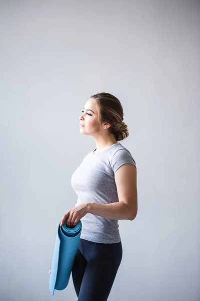 Portret van een meisje houden blauwe yoga mat. — Stockfoto