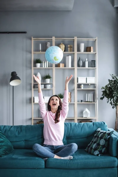 Jubiloso joven exitoso planeando unas vacaciones con el mundo . — Foto de Stock