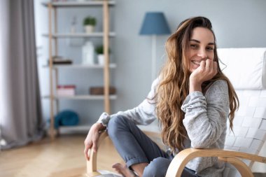 Evde kameraya gülümseyen kadın portresi. 