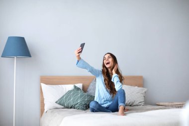 Güzel mutlu kız kendini yatağa evde yapma.