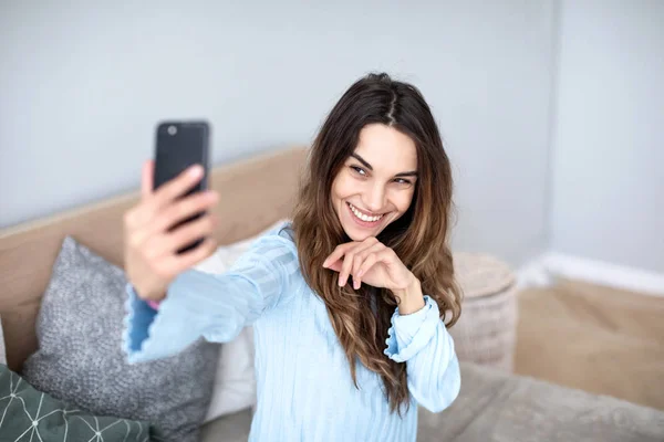 Beautiful young woman taking selfie at home. — Stock Photo, Image