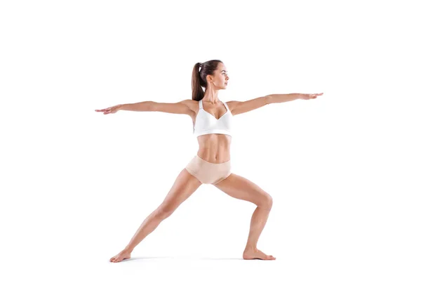 Jovem atraente fazendo exercício de ioga Virabhadrasana, isolado no fundo branco . — Fotografia de Stock