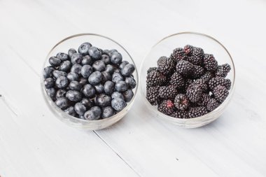 Yaban mersini ve blackberry bir ahşap masa üstü görünümü ile plakalar. 