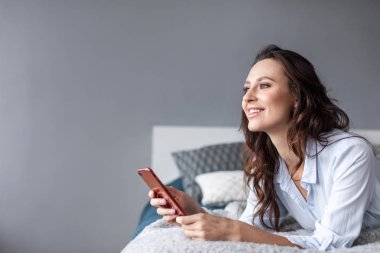 Cep telefonu yatak evde kullanan kadın. 