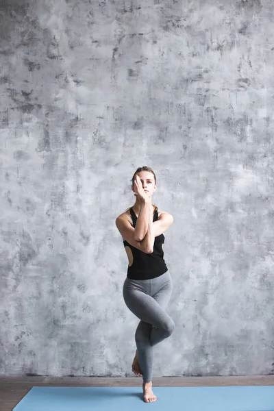 Fullängds porträtt av unga vackra kvinnan gör yoga träning inomhus. — Stockfoto