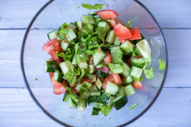 Salata taze domates, salatalık ve yeşil salata ile ahşap arka plan üstten görünüm üzeri yağlıboya. 