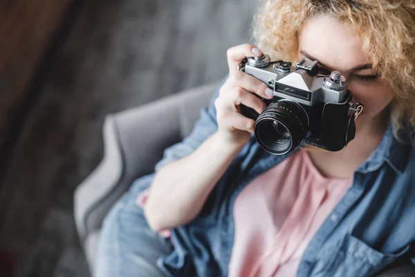 Portrait of a beautiful young woman with a camera at home. — Stock Photo, Image