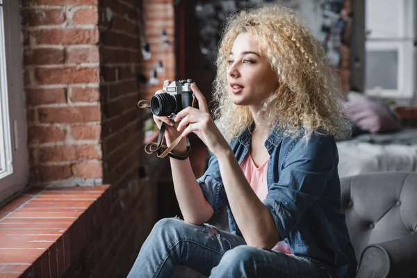 Woman with a retro photo camera at home. — Stock Photo, Image