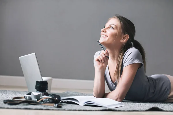 Positive girl with laptop dreams on the floor. — Stock Photo, Image