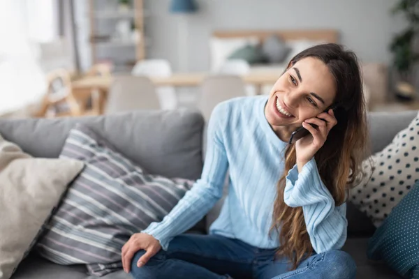 Mujer sonriente hablando por teléfono en casa en el sofá . —  Fotos de Stock
