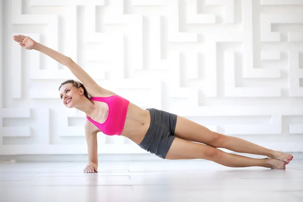 Joyeux et belle femme faire des exercices de yoga à la maison . — Photo