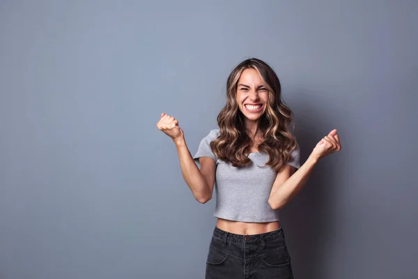 Cheerful woman clenching fists, exclaiming with joy and excitement. — Stock Photo, Image